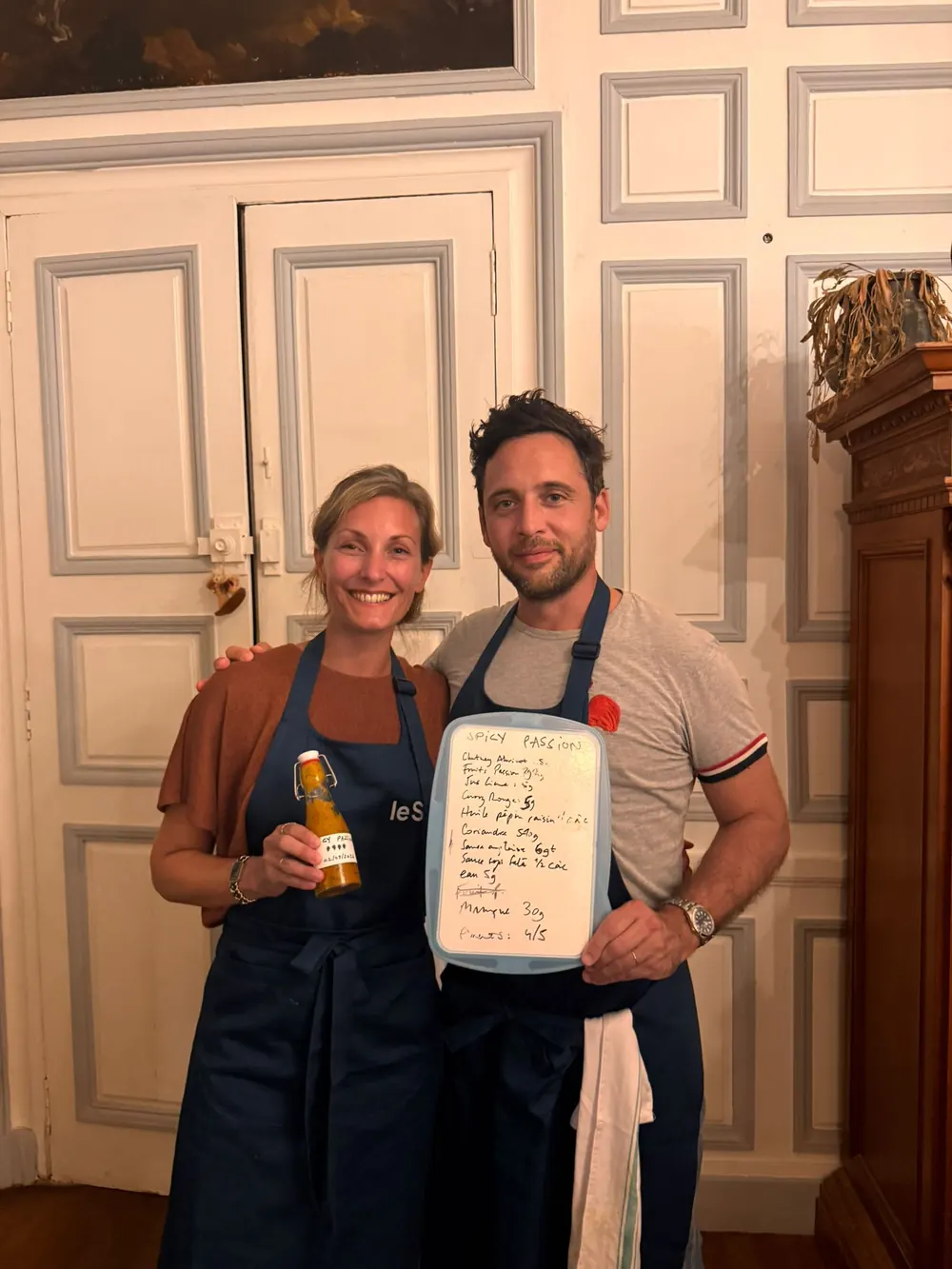 Un binôme présente sa création : bouteille étiquetée et recette écrite à la main.